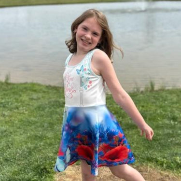 Blue girls’ sundress with butterfly and flower design, “I love you” message, part of Paisley’s Corner Collection, lightweight polyester-spandex blend, ideal for summer and special occasions, girl in butterfly sundress